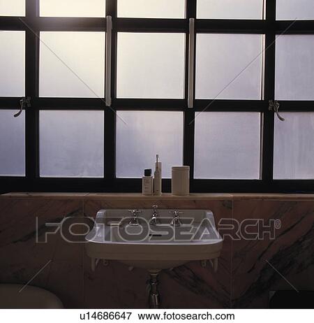 Close-up of white basin below windows with square black frames View Large Photo Image Stock Photo - Close-up of white basin below windows with square black frames. Fotosearch