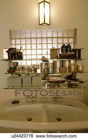 Close-up of white china and stainless steel storage cans on glass shelves above double white basins View Large Photo Image Stock Photo - Close-up of white china and stainless steel storage cans on glass shelves above double white basins. Fotosearch
