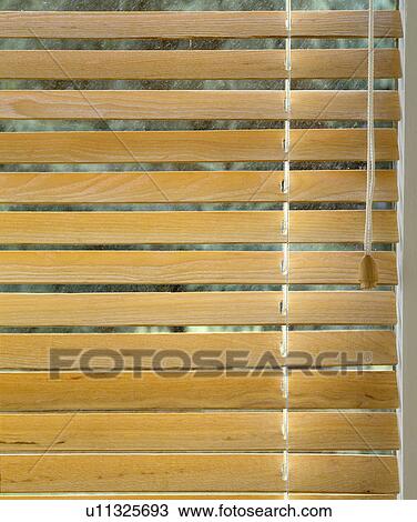 Stock Image - Closeup of pale wooden venetian blind.. Fotosearch