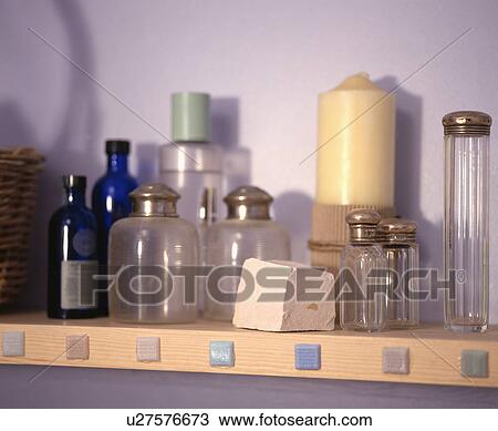 Stock Image - Collection of silver topped storage bottles on bathroom shelf. Fotosearch