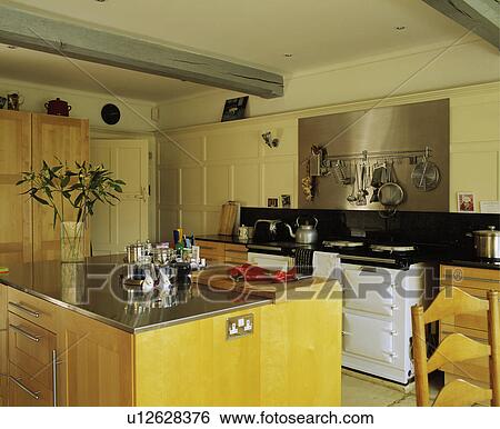 Stock Photograph - Contemporary wooden kitchen with white aga and island unit.. Fotosearch