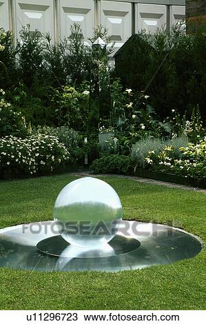 Corner of a modern town garden with silver and white planting with a mirrored obelisk and cicular water feature. View Large Photo Image Stock Image - Corner of a modern town garden with silver and white planting with a mirrored obelisk and cicular water feature.. Fotosearch