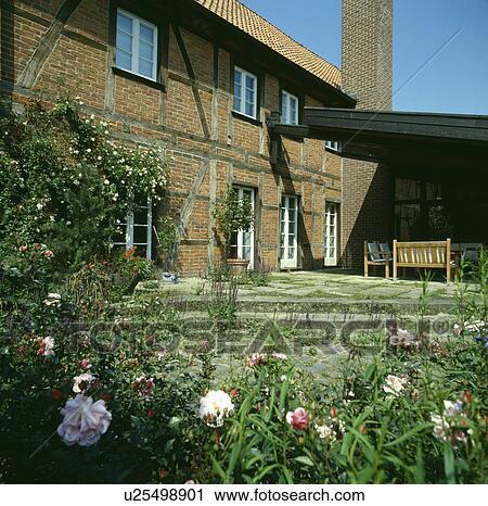 Stock Image - Courtyard in front of traditional brick country house. Fotosearch
