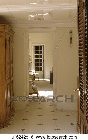 Cream tiled floor in white hall with open doorway to living room View Large Photo Image Stock Photograph - Cream tiled floor in white hall with open doorway to living room. Fotosearch