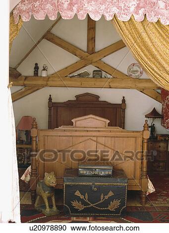Decorated antique boxes in attic country bedroom with pine bed View Large Photo Image Stock Image - Decorated antique boxes in attic country bedroom with pine bed . Fotosearch