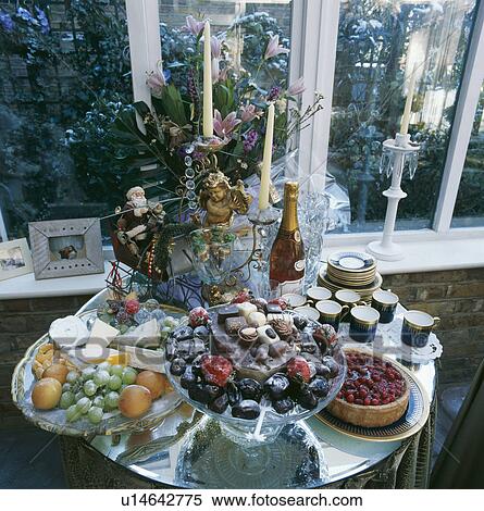 Desserts and cheeses with champagne and chocolates on small circular table decorated for Christmas View Large Photo Image Stock Photography - Desserts and cheeses with champagne and chocolates on small circular table decorated for Christmas. Fotosearch