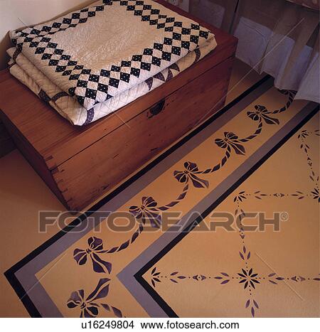 Picture - Detail of rug painted on floor and chest at foot of bed.. Fotosearch