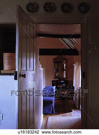 Stock Image - Door open to traditional cottage living room. Fotosearch