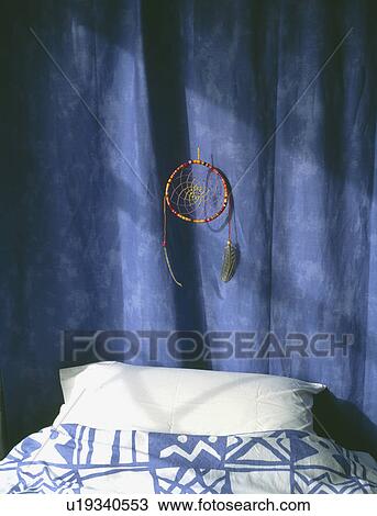 Dreamcatcher on blue curtain above bed with white pillow View Large Photo Image Stock Image - Dreamcatcher on blue curtain above bed with white pillow. Fotosearch