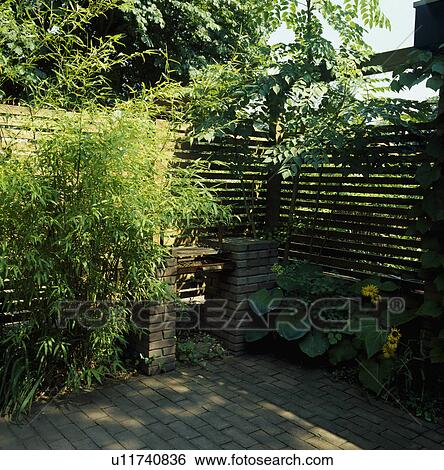 Stock Photograph - Fence in green country garden in summer. Fotosearch