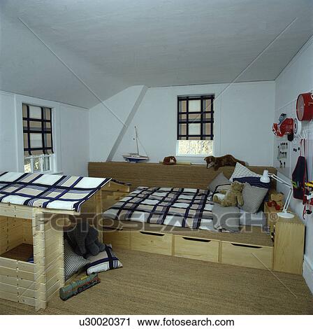 Stock Image - Fitted unit with storage drawers beneath bed with checked linen and matching blinds in children's bedroom. Fotosearch