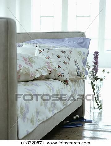Floral pillows and linen on upholstered grey bed View Large Photo Image Stock Image - Floral pillows and linen on upholstered grey bed. Fotosearch