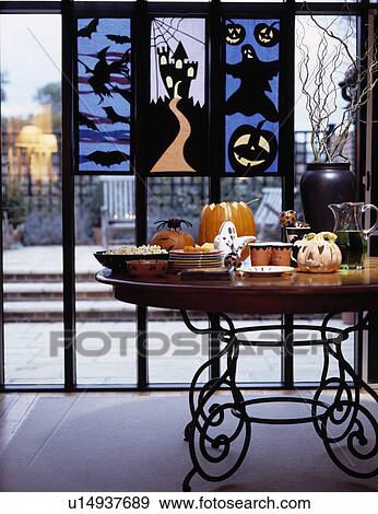 Foof on table with metal legs in modern dining room with Halloween pictures on large windows View Large Photo Image Stock Photo - Foof on table with metal legs in modern dining room with Halloween pictures on large windows. Fotosearch