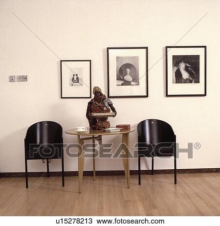 Framed large black+white photographs on wall above modern black chairs and sculpture on circular table View Large Photo Image Stock Image - Framed large black+white photographs on wall above modern black chairs and sculpture on circular table . Fotosearch