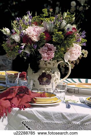 Stock Photography - Fresh flowers in floral jug on table. Fotosearch