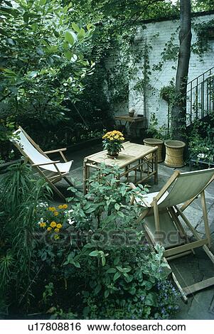 Stock Photograph - Furniture on patio in town garden in summer. Fotosearch