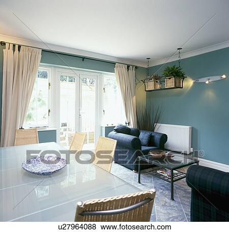Glass Table And Wicker Chairs In Green Blue Dining Room With Cream Curtains At Patio Doors Glass Table And Wicker Chairs In Green Blue Dining Room With Cream Curtains At Patio Doors