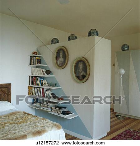 Graduated bookshelves on pale blue and white dividing wall in white bedroom View Large Photo Image Stock Image - Graduated bookshelves on pale blue and white dividing wall in white bedroom. Fotosearch