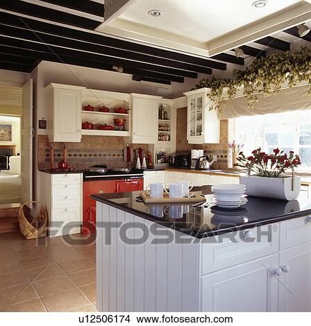 Granite-topped white island unit in modern country kitchen with red Aga View Large Photo Image Picture - Granite-topped white island unit in modern country kitchen with red Aga. Fotosearch