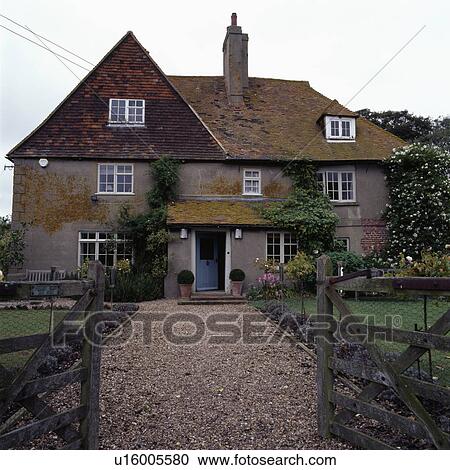 Stock Image - Gravel drive to traditional house in the country. Fotosearch