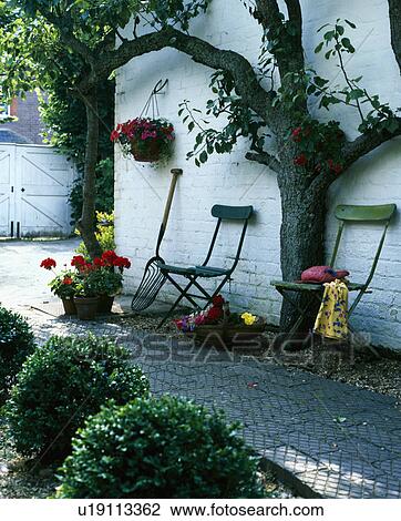 Green chairs against white house wall with pear tree and brick path View Large Photo Image Stock Image - Green chairs against white house wall with pear tree and brick path. Fotosearch