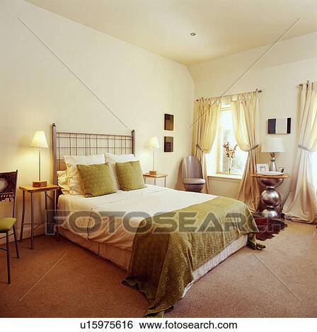 Green cushions and throw on bed in cream bedroom with pale brown carpet and cream curtains View Large Photo Image Stock Photograph - Green cushions and throw on bed in cream bedroom with pale brown carpet and cream curtains. Fotosearch