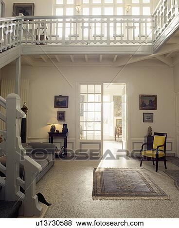 Grey rug on terrazo floor in large hall with sofa and yellow chair View Large Photo Image Stock Photo - Grey rug on terrazo floor in large hall with sofa and yellow chair. Fotosearch