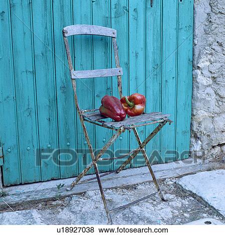 Gros Plan De Poivres Sur Vieux Chaise Jardin Devant Turquoise Porte Bois Banque De Photo