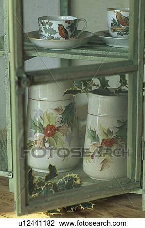 Holly and robin patterned jug and cups in old pastel green cupboard with glass door View Large Photo Image Stock Image - Holly and robin patterned jug and cups in old pastel green cupboard with glass door. Fotosearch