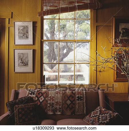 Stock Image - Kelim rug on sofa below window. Fotosearch
