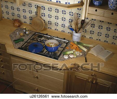 Kitchen with close-up of gas hob unit and sliced vegetables on wooden worktop View Large Photo Image Stock Image - Kitchen with close-up of gas hob unit and sliced vegetables on wooden worktop. Fotosearch