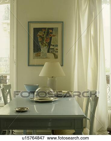 Lamp and glass dish on pastel blue table in dining room with white curtains View Large Photo Image Stock Photo - Lamp and glass dish on pastel blue table in dining room with white curtains. Fotosearch