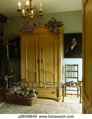 Large antique pine wardrobe and oil painting in green country hall with basket of logs View Large Photo Image Stock Photo - Large antique pine wardrobe and oil painting in green country hall with basket of logs. Fotosearch
