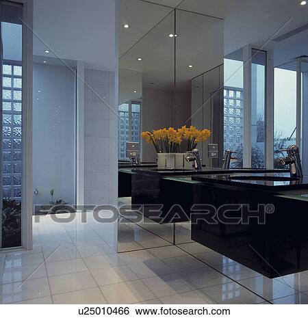 Stock Photograph - Large black and white architectural bathroom with mirrored walls and doors. Fotosearch