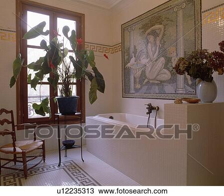 Large houseplant on table in front of window in bathroom with black+white tiled floor and mosaic picture above bath View Large Photo Image Stock Image - Large houseplant on table in front of window in bathroom with black+white tiled floor and mosaic picture above bath . Fotosearch