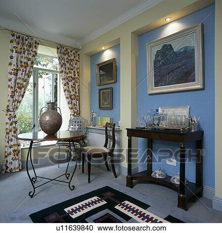 Large metal pot on circular glass and metal table in blue dining room with recessed lighting above pictures View Large Photo Image Stock Image - Large metal pot on circular glass and metal table in blue dining room with recessed lighting above pictures. Fotosearch