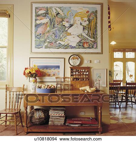 Large picture above miniature dresser and chairs on old wood table in openplan traditional hall View Large Photo Image Picture - Large picture above miniature dresser and chairs on old wood table in openplan traditional hall. Fotosearch
