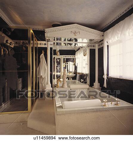 Large rectangular marble bath below pillars with pediment in black+white neo-classical bathroom View Large Photo Image Picture - Large rectangular marble bath below pillars with pediment in black+white neo-classical bathroom. Fotosearch
