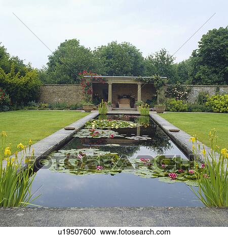 Stock Image - Large rectangular pond in country garden. Fotosearch