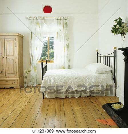 Large traditional white bedroom with wooden floor boards and white bedding View Large Photo Image Stock Photo - Large traditional white bedroom with wooden floor boards and white bedding . Fotosearch