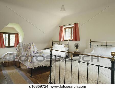 Large white bedroom in the eaves of an attic conversion with twin iron bead steads View Large Photo Image Picture - Large white bedroom in the eaves of an attic conversion with twin iron bead steads. Fotosearch