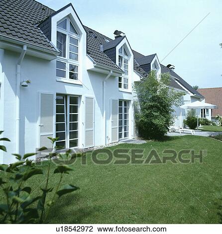 Lawn in front of traditional house with large windows View Large Photo Image Stock Image - Lawn in front of traditional house with large windows. Fotosearch