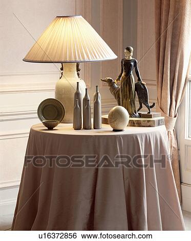 Lighted lamp and Thirties statue on table View Large Photo Image Stock Photograph - Lighted lamp and Thirties statue on table. Fotosearch