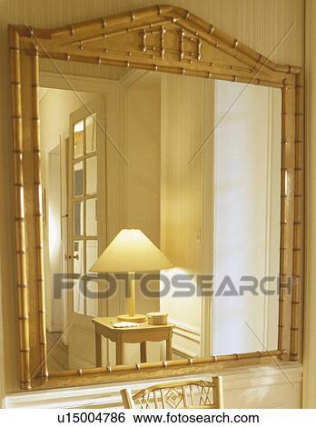 Lighted lamp reflected in bamboo mirror in cream hall View Large Photo Image Stock Photograph - Lighted lamp reflected in bamboo mirror in cream hall. Fotosearch