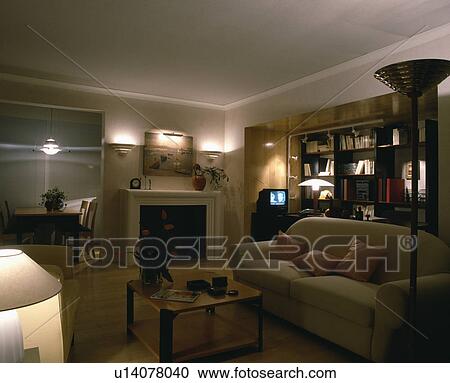 Stock Image - Lighted lamps in modern living room with television. Fotosearch