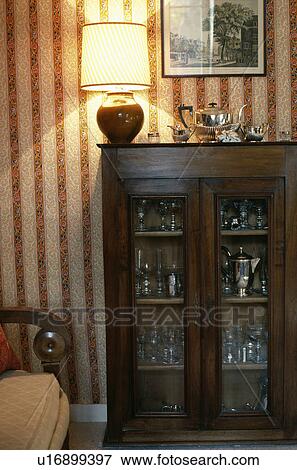 Lighted lamps on china glass-front cupboard in traditional living room View Large Photo Image Stock Photo - Lighted lamps on china glass-front cupboard in traditional living room. Fotosearch