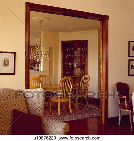 Stock Photo - Livingroom with double doorway to modern diningroom with large chandelier. Fotosearch