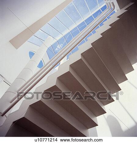 Looking upwards to underneath of modern stone staircase in white hall with glass skylight View Large Photo Image Picture - Looking upwards to underneath of modern stone staircase in white hall with glass skylight. Fotosearch