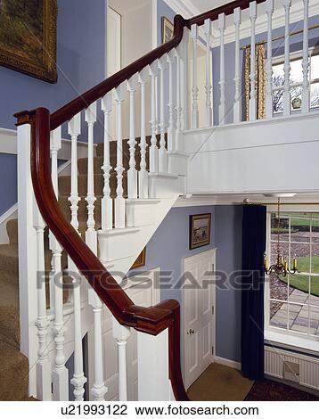 Mahogany handrail above white wooden bannisters on white staircase in blue country hall View Large Photo Image Stock Image - Mahogany handrail above white wooden bannisters on white staircase in blue country hall. Fotosearch