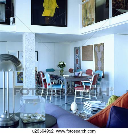 Metal table and chairs in openplan dining and living room in white loft conversion View Large Photo Image Stock Image - Metal table and chairs in openplan dining and living room in white loft conversion. Fotosearch